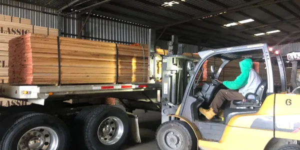 Loading lumber on freight truck.